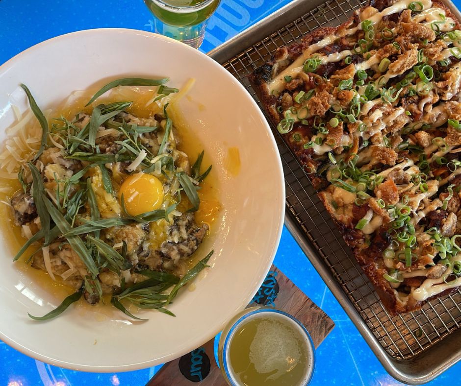 table of pasta, beer and pizza on interactive table at Graffiti Market