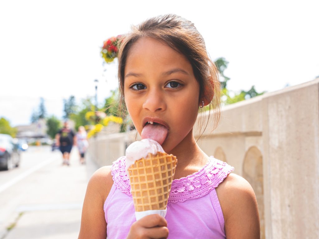 young girl licking an ice cream cone from pump house creamery