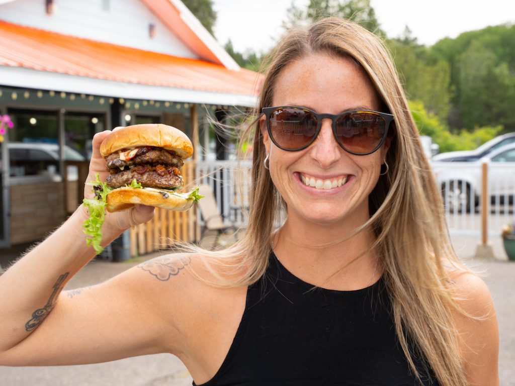Nicole holding up the Eddy Burger in Thunder Bay