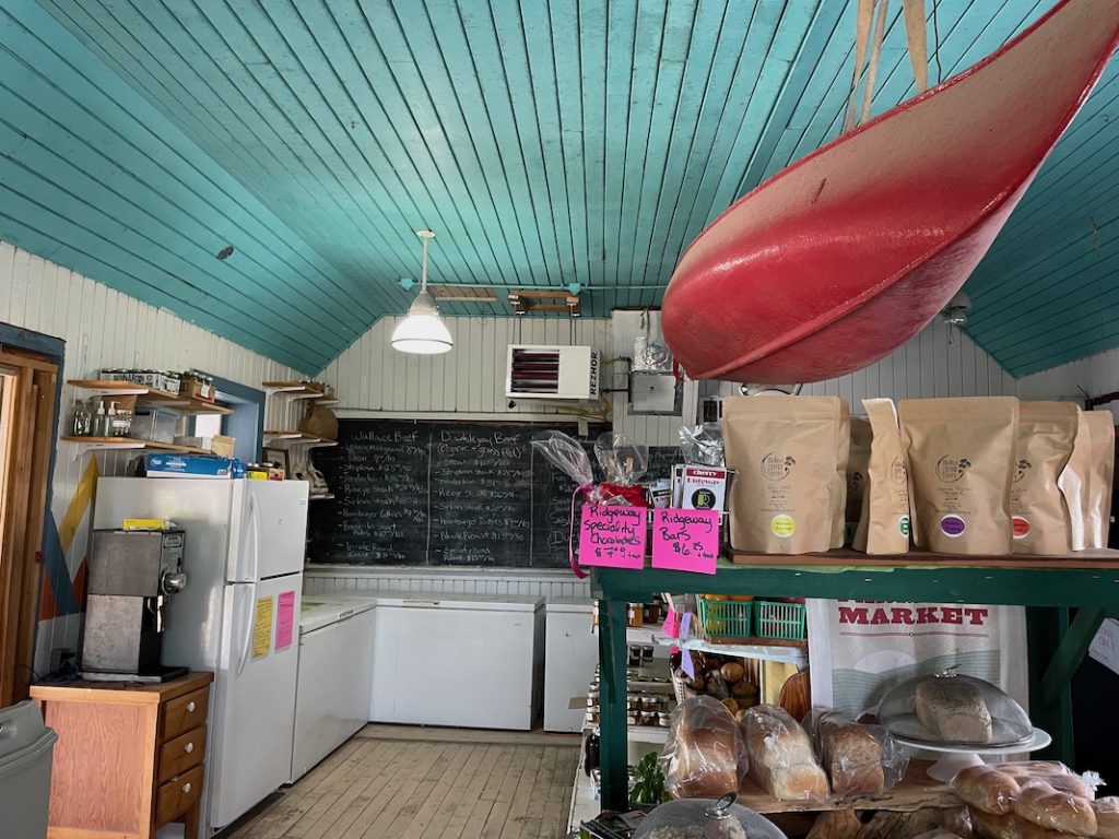 The interior of Wendy's Country Market with a bright blue ceiling and red canoe hanging from it