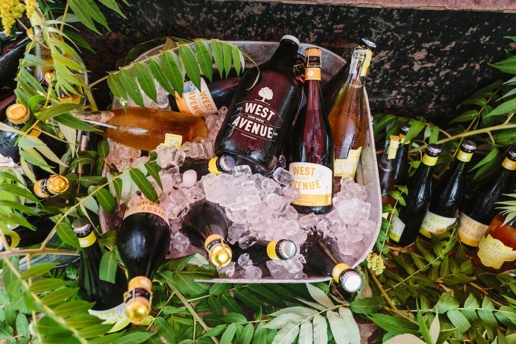 photo of a bunch of bottles and a growler of west avenue cider in an ice bucket