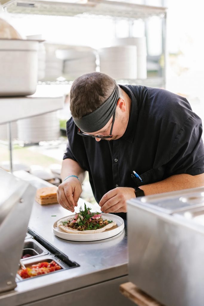 Chef in the kitchen at 13th street winery carefully plating a dish
