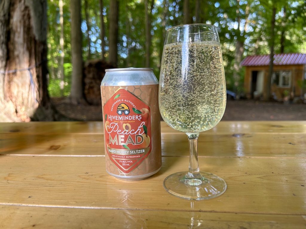 Can and glass of peach mead on the table at Ontario Honey Creations