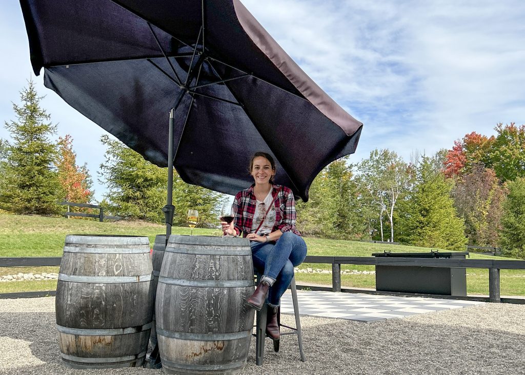 woman enjoying a glass of wine on the patio at Windrush estate winery