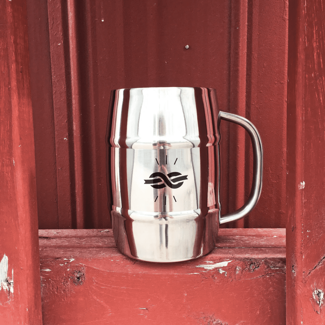 1L beer mug from mackinnon brothers brewing against a red barn wall