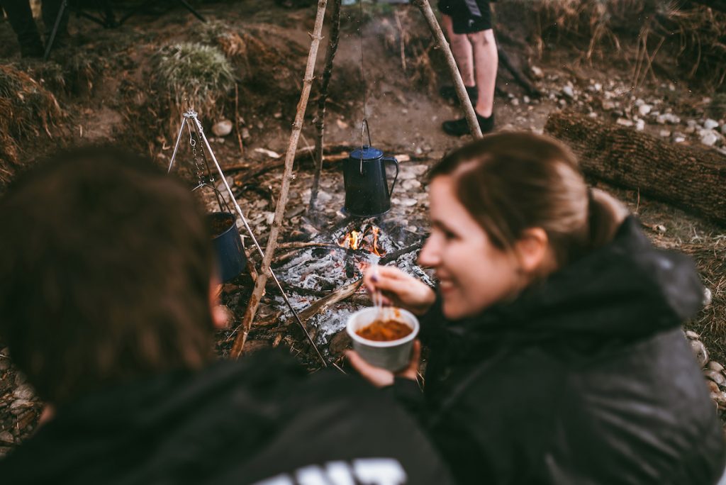 couple enjoying chili on the shore