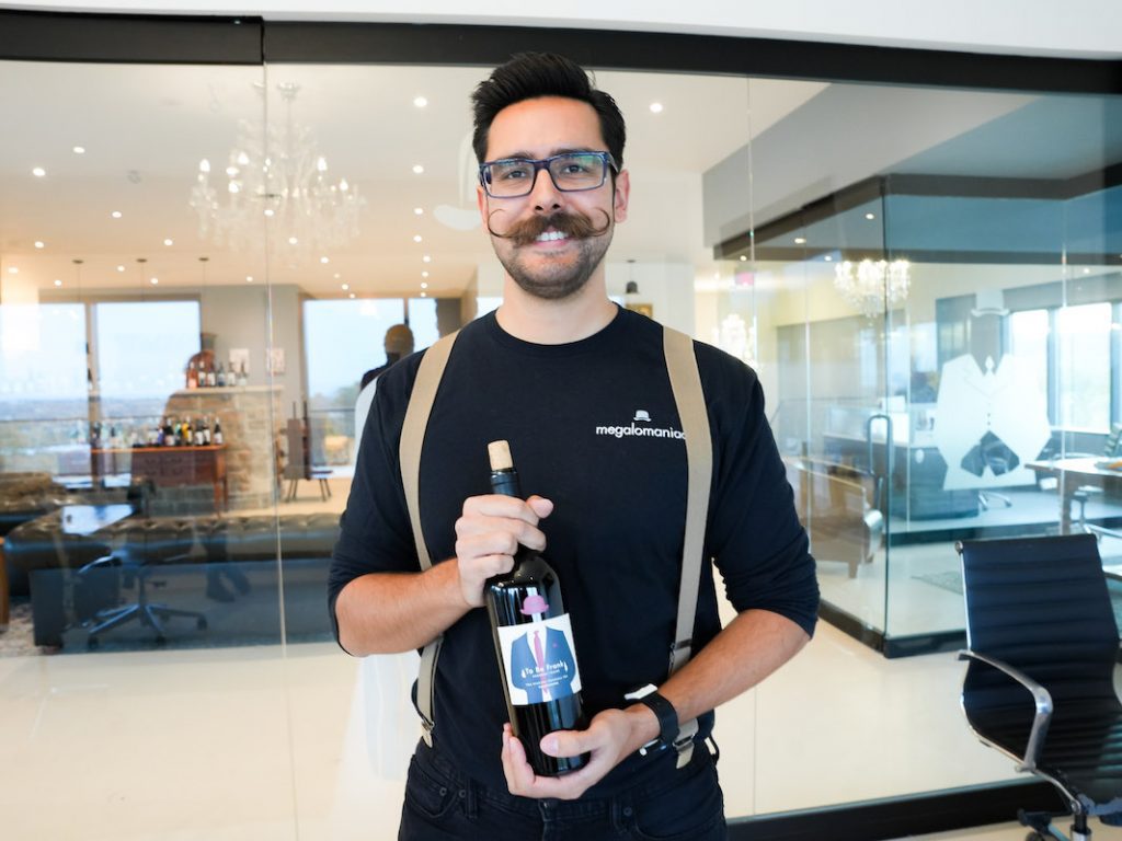 Fernando holding a bottle of Megalomaniac Wines in the tasting room