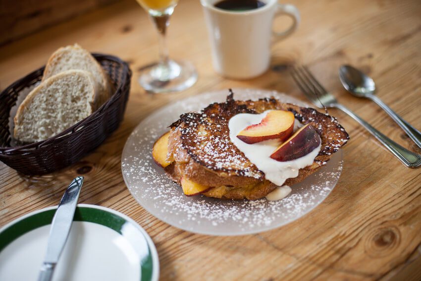 A plate of French toast and sliced peaches