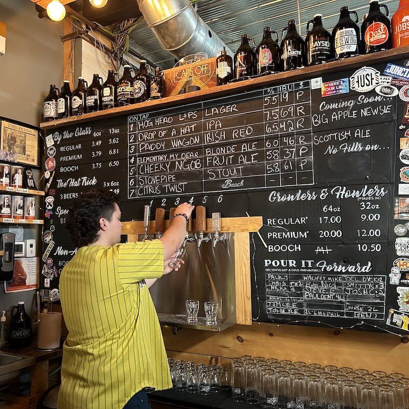 pouring a beer off the tap at Caps off Brewing