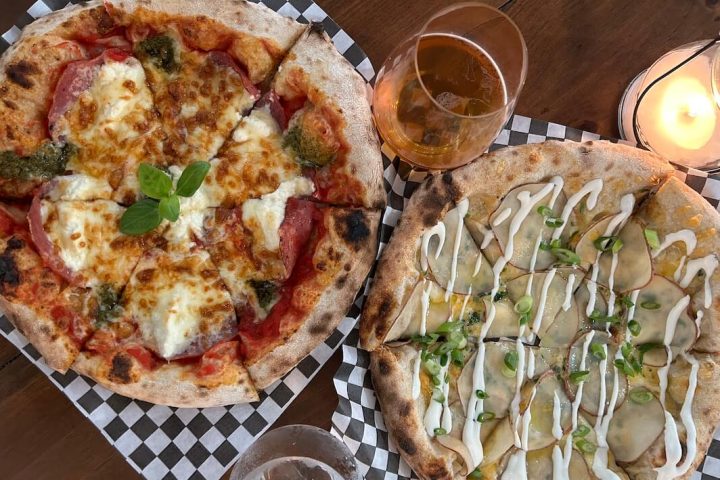 overhead shot of two wood fired pizzas at Elgin Harvest with two drinks