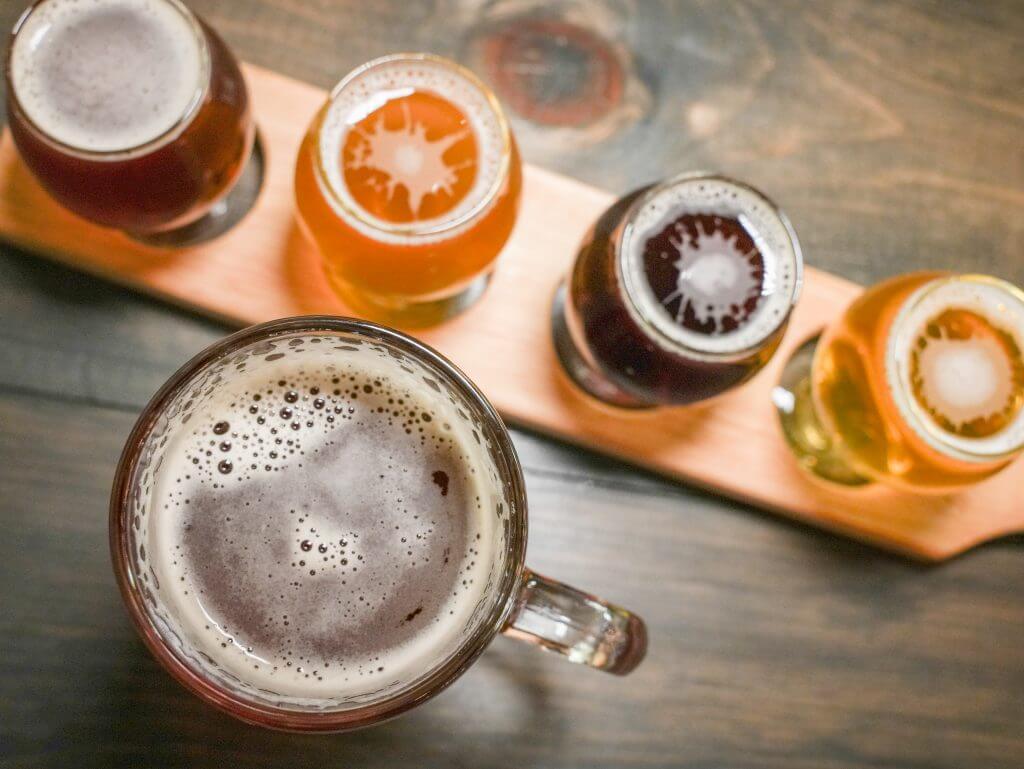 overhead shot of a flight and a large mug of beer at Newark Brewing Company