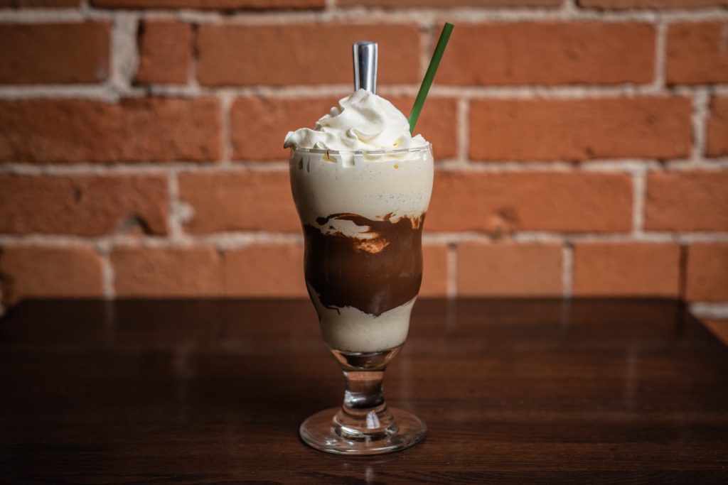 milkshake at harper's burger bar against a brick background on a dark table