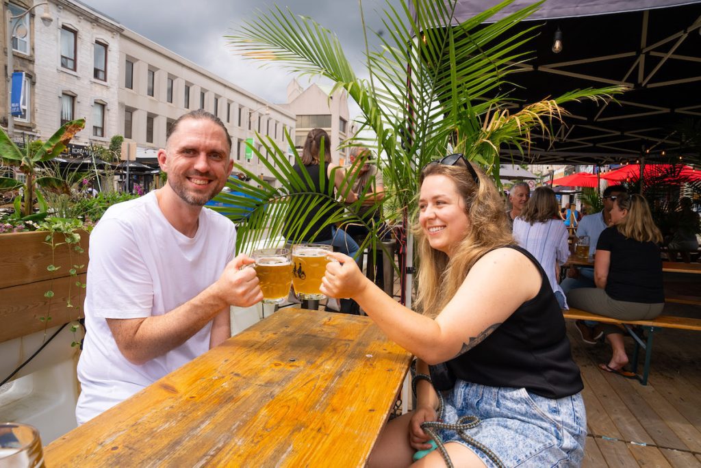 Ian and Chelsea cheersing their beer on the patio at Brothers Brewing