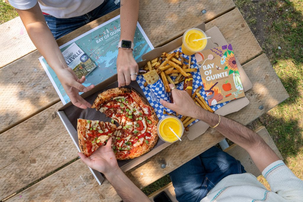 an overhead shot of all the food we got at pop ups on the bay for pizza, fries and bay of quinte magazine