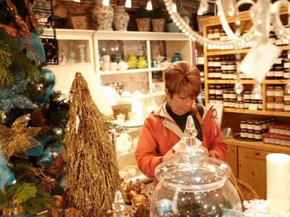 Woman looking at item inside of boutique store decorated for the holidays