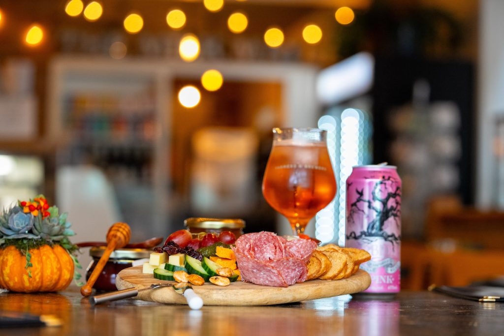 charcuterie spread at the milk maid with coffin ridge cider can and poured into glass