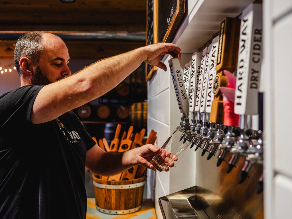 man pouring a cider off the tap at Hardway Cider Co.