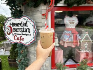 a cold candy cane drink held up to bearded barista storefront