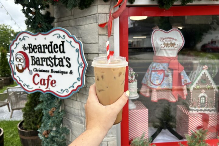 a cold candy cane drink held up to bearded barista storefront