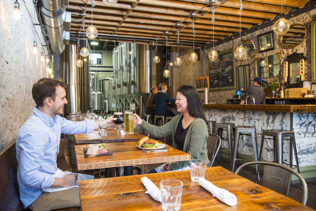 Two people cheersing at Elora Brewing Company