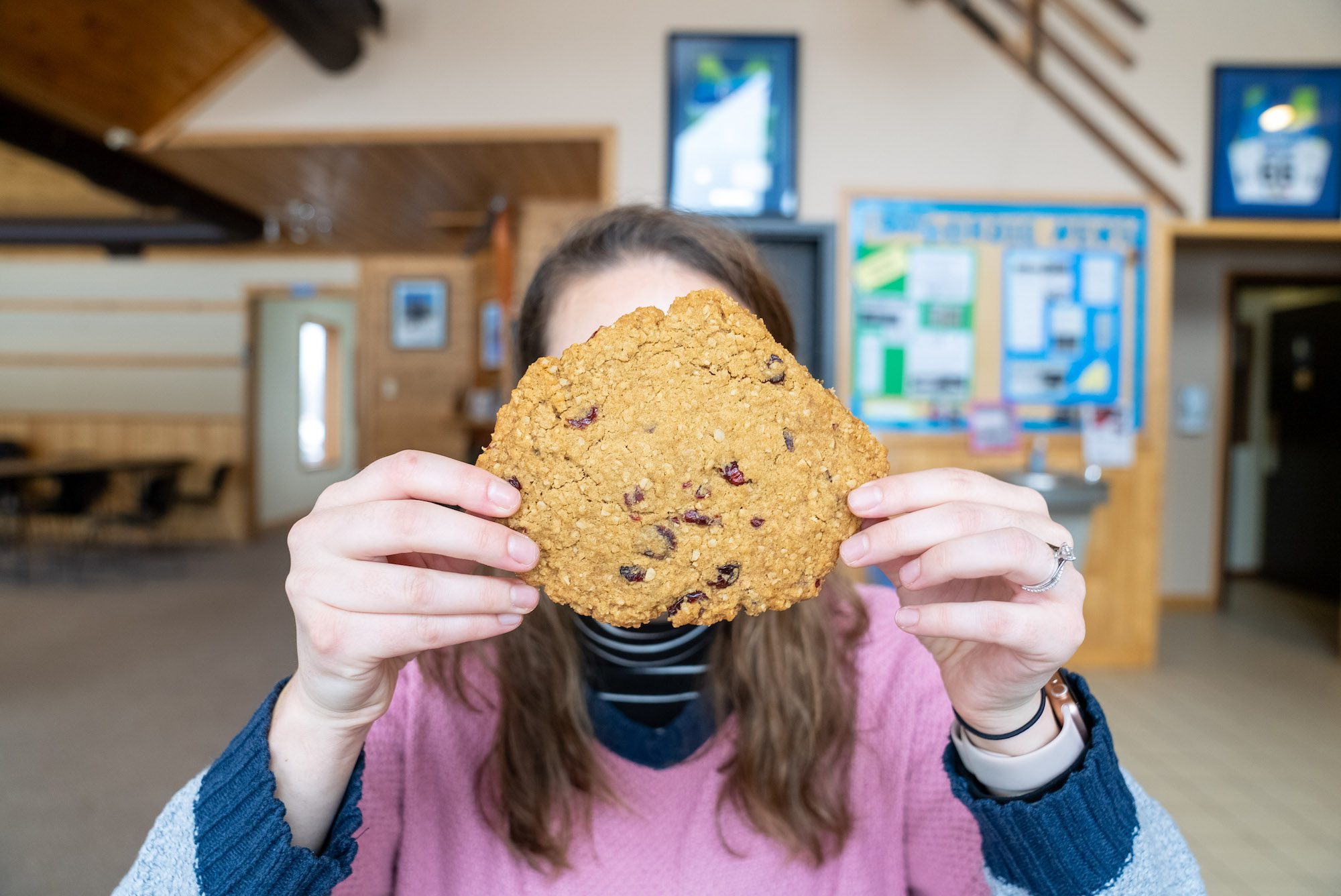 Person holding a giant cookie in front of their face at Kamview Nordic Centre