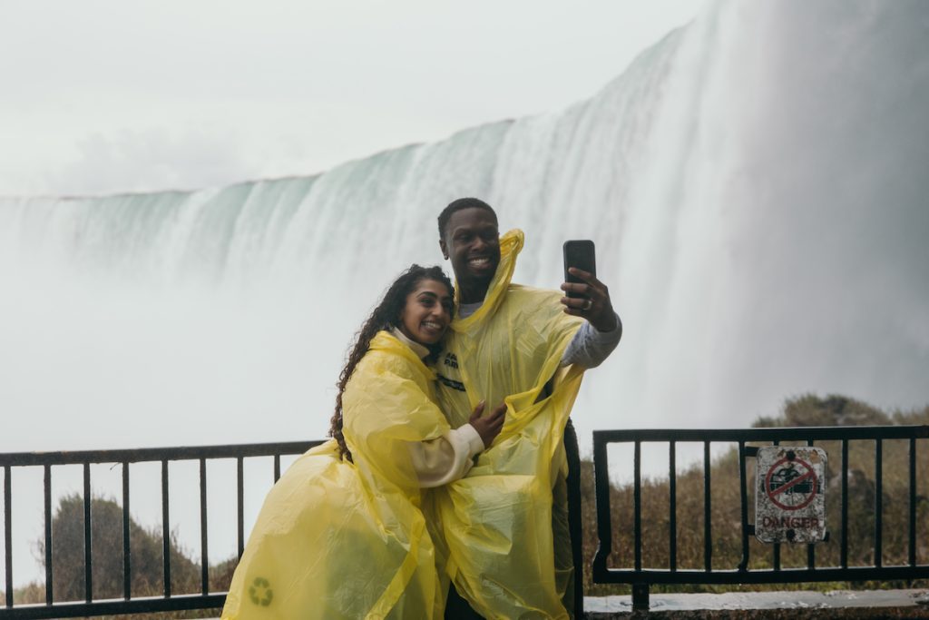 couple snaps a photo at journey behind the falls