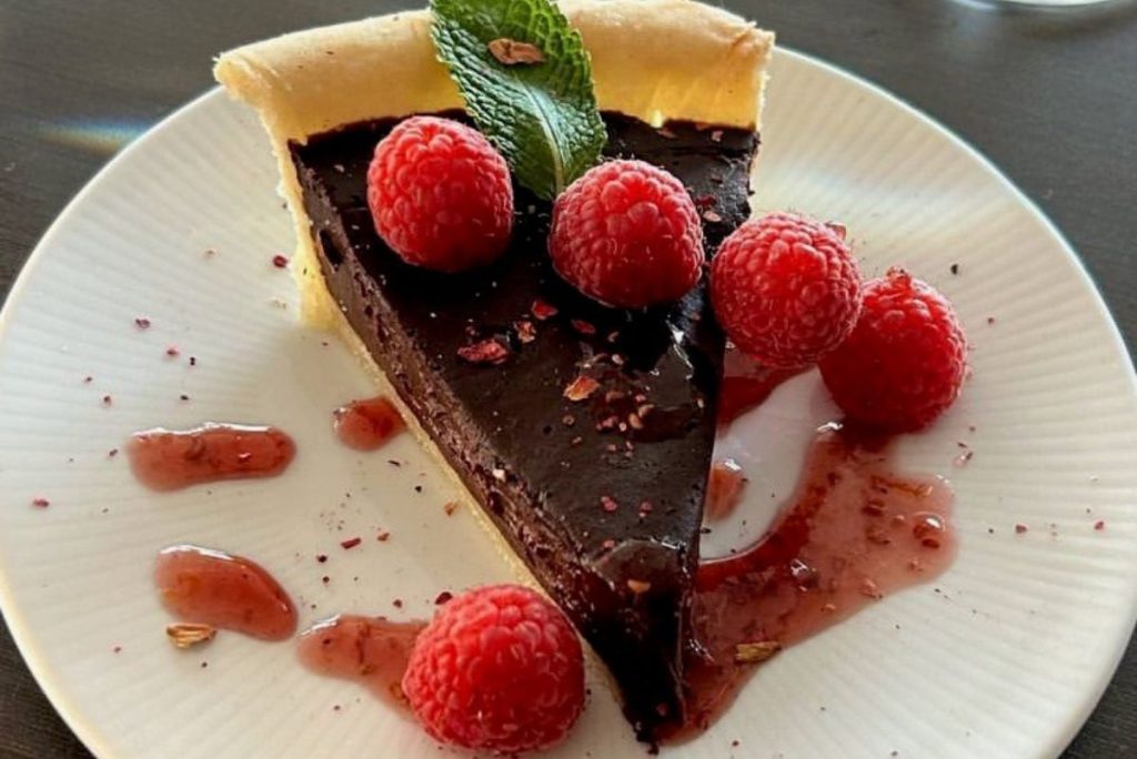 Slice of chocolate dessert with raspberries