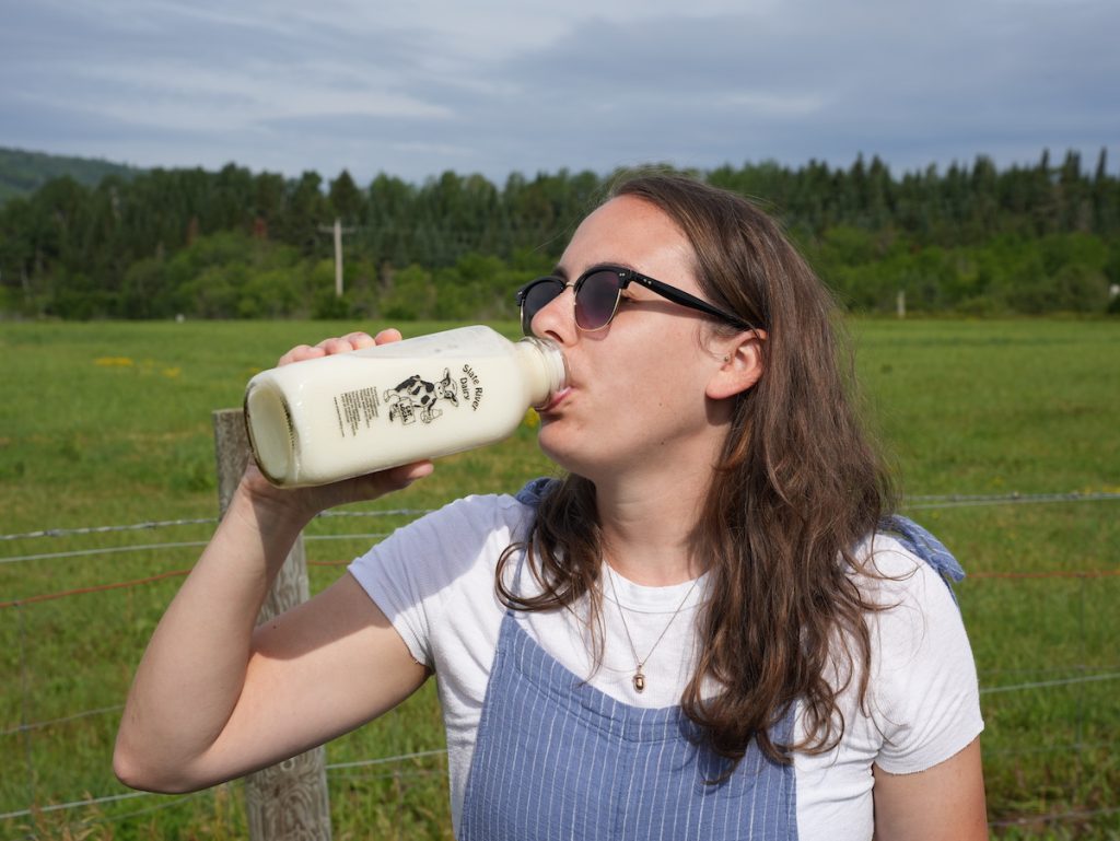 Girl drinking milk outside at Slate River Dairy straight from the bottle