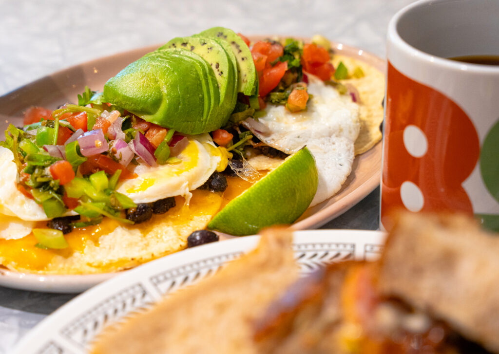close up of a plate with eggs topped with avocado and tomato salsa.