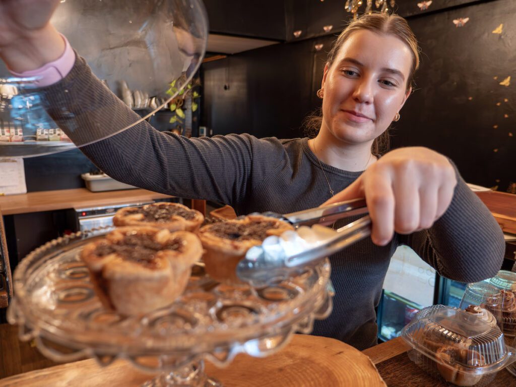 girl grabbing a butter tart with tongs at Black Honey