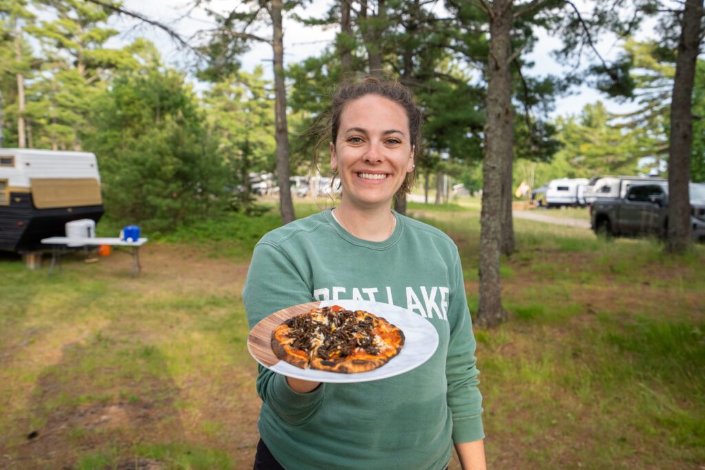 Gabby holding out pizza at Thrive Tours