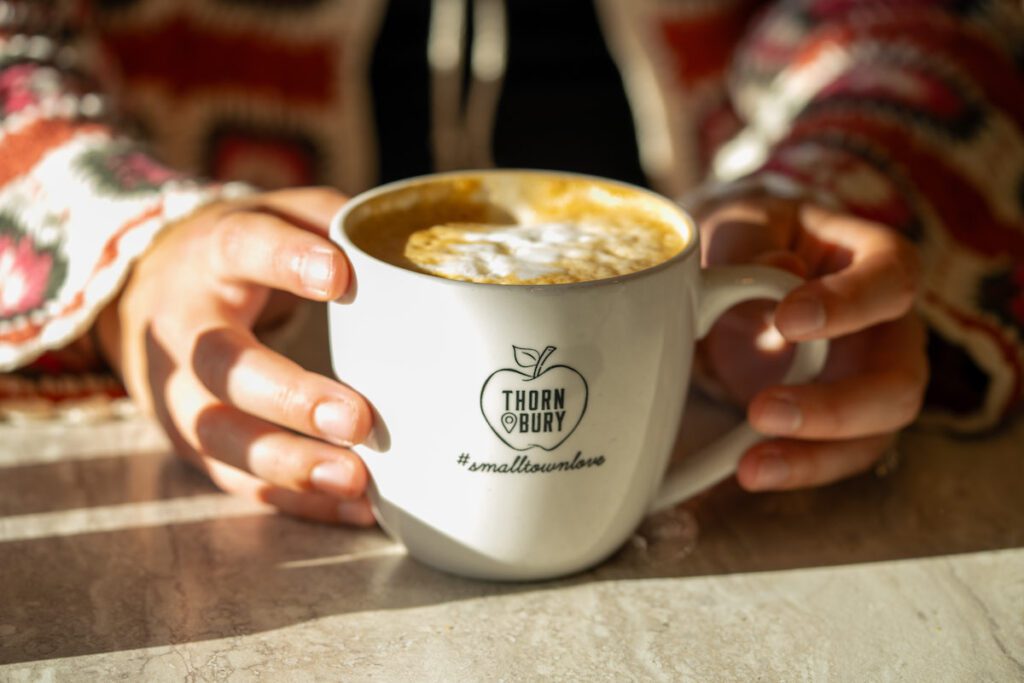 close up of two hands holding a mug from Thornbury Bakery Cafe