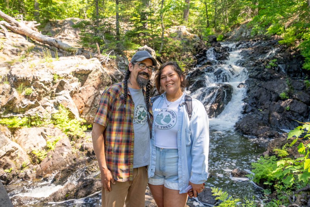 Mario and Cheyene from Walk Among the Trees in front of waterfalls