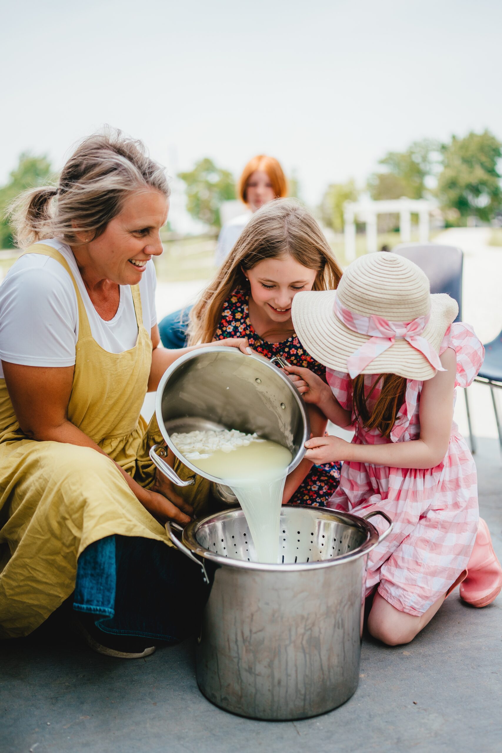 image of farmer with child pouring fresh milk from bucket into another bucket