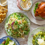 Overhead shot of table at Ernie's Coffee Shop with plates if fries, salads, a chicken sandwich, and gnocchi dish