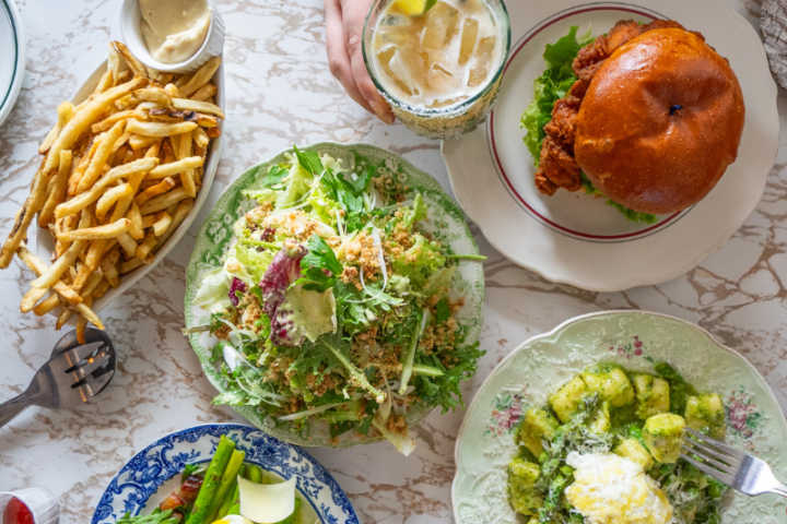 Overhead shot of table at Ernie's Coffee Shop with plates if fries, salads, a chicken sandwich, and gnocchi dish