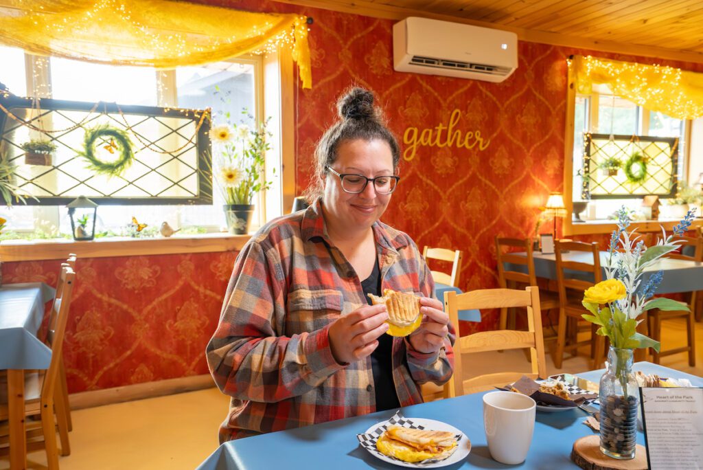 sarah looking at a breakfast sandwich at wattle and daub