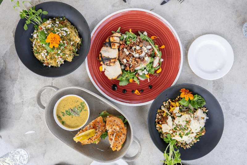 Long shot of four dishes served on the patio at Puddicombe House 