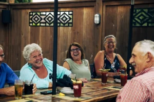 Group of 5 people enjoying beverages at a table on a patio at Crown and Turtle Pub