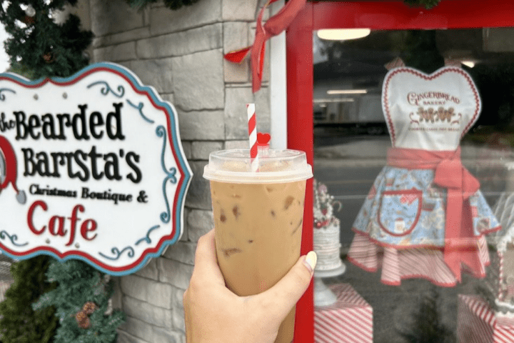 holding a drink up to the sign at Bearded Barista