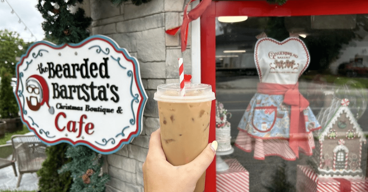 holding a drink up to the sign at Bearded Barista