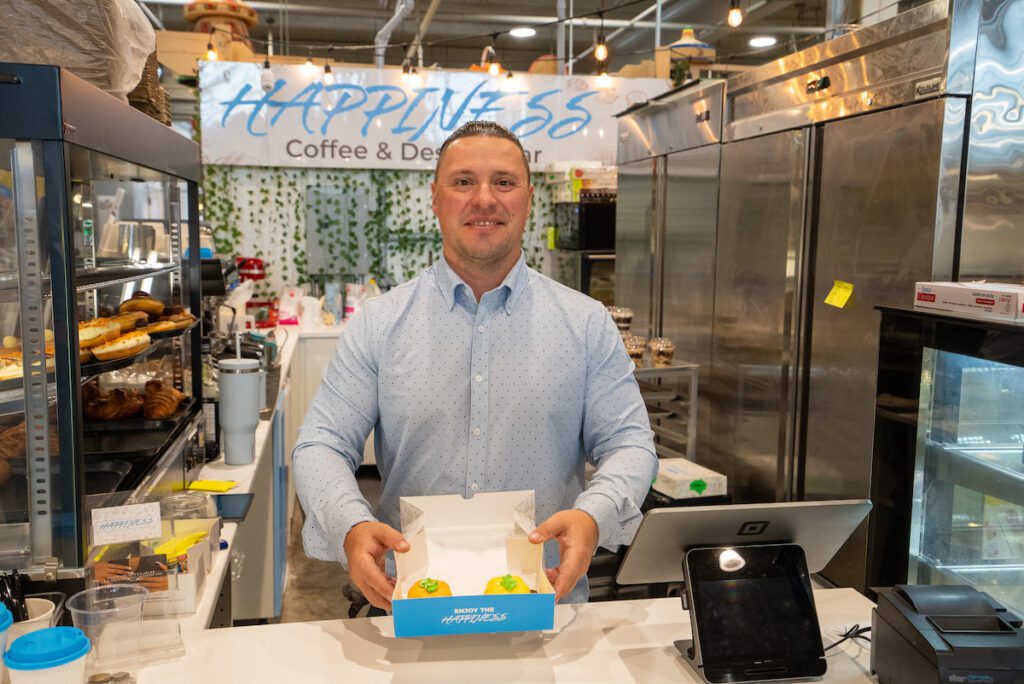 man holding pastries at the Happiness Cafe at Covent Garden Market