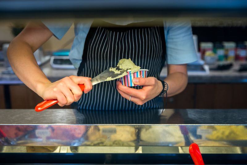 close up of server scooping gelato into cup.