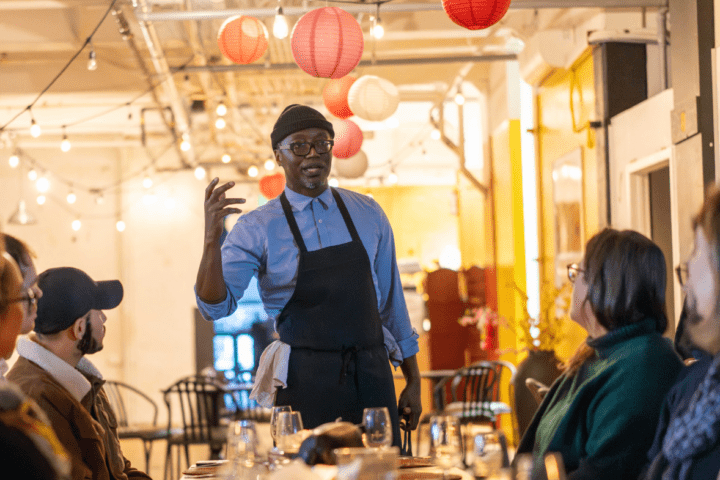 Malvin speaking to the table at Yaya's Kitchen