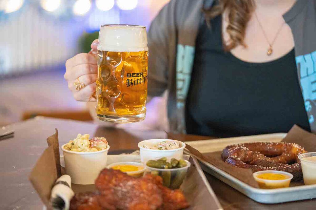 holding a beer behind the schniztel platter at Beer Kitchen