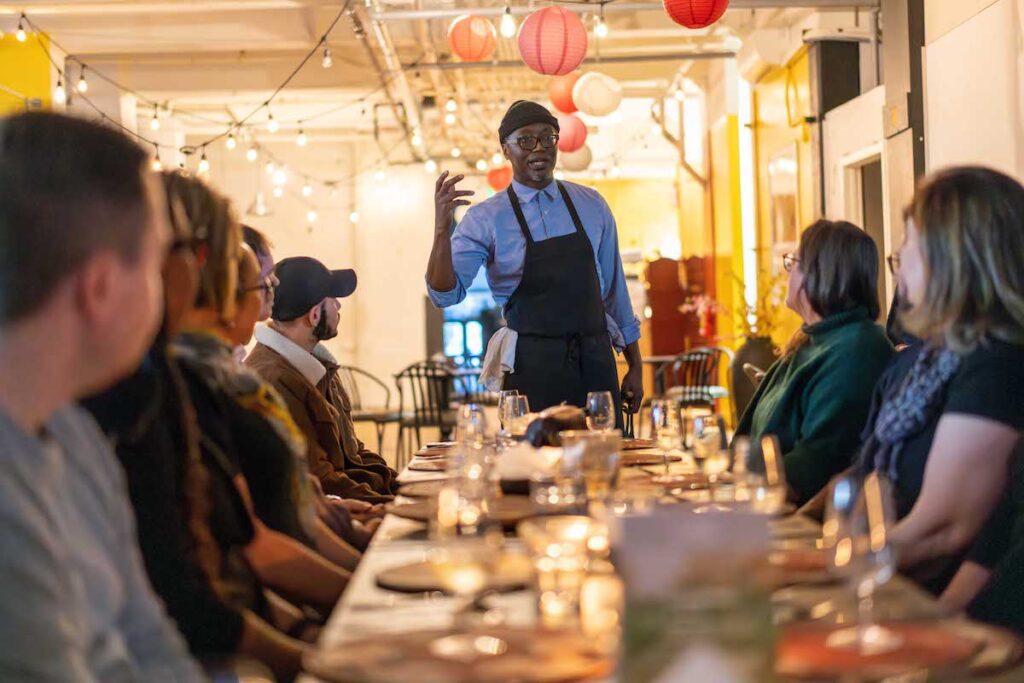 Malvin guiding the table through one of the courses at Yaya's Kitchen